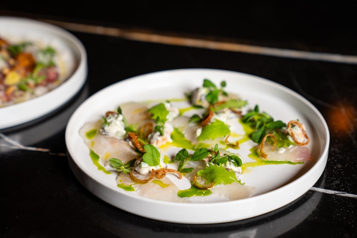 A carpaccio dish on a white plate | Winterlicious 2025