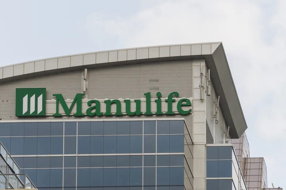 Manulife building with a green logo on the exterior, featuring glass windows and a modern architectural design.
