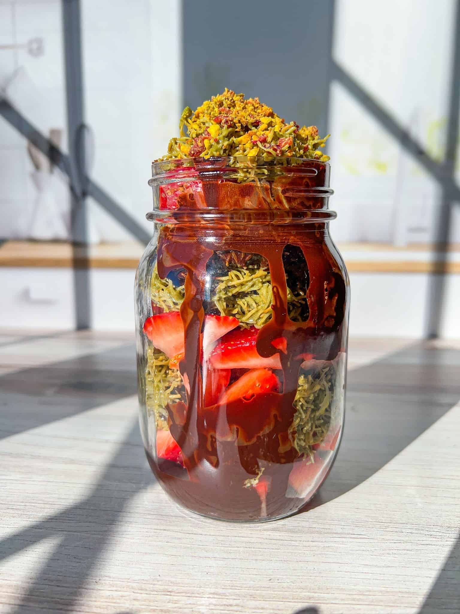 Dubai covered strawberries layered in a mason jar.