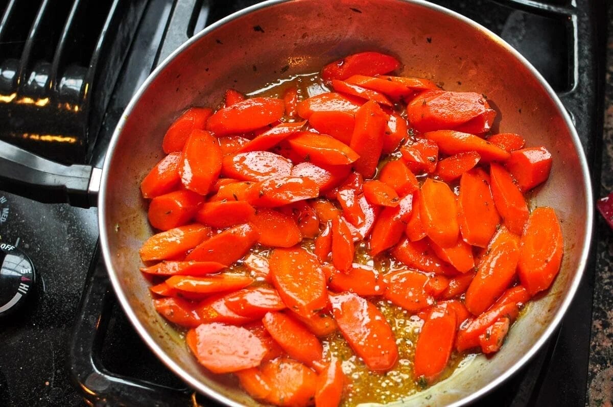 Honey glazed carrots cooking in a pan