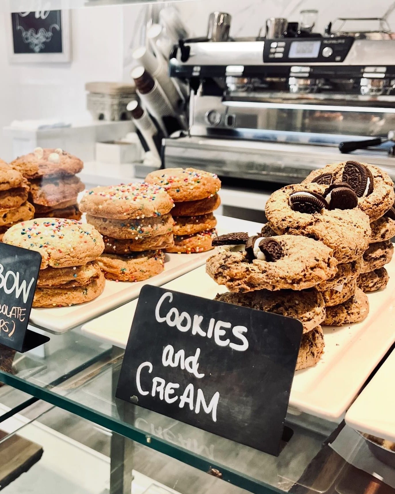 Colorful rainbow sprinkle cookies and Oreo-studded cookies on display in a cozy café in Toronto’s Distillery Historic District