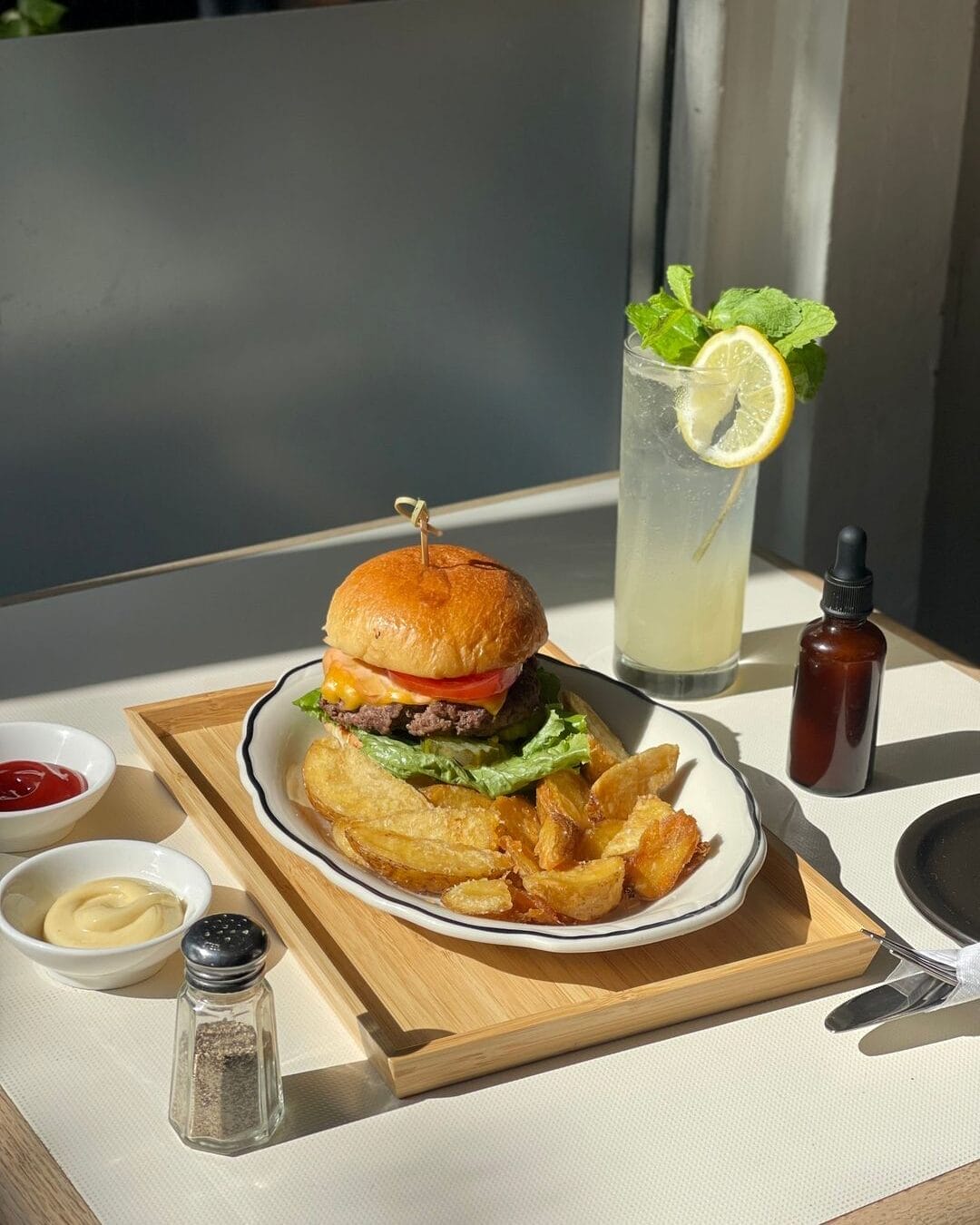 burger with fries and lemonade on the side