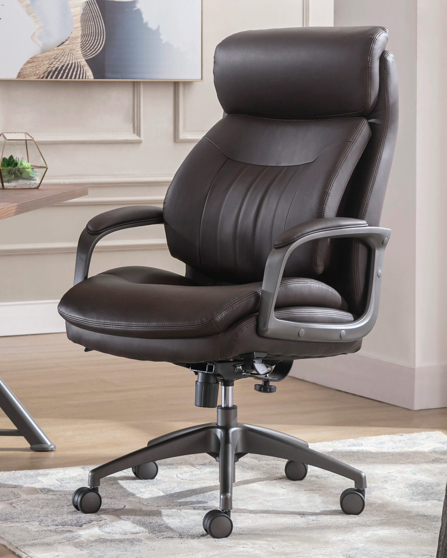 Brown leather office chair with arms, featuring a sleek design suitable for professional environments.