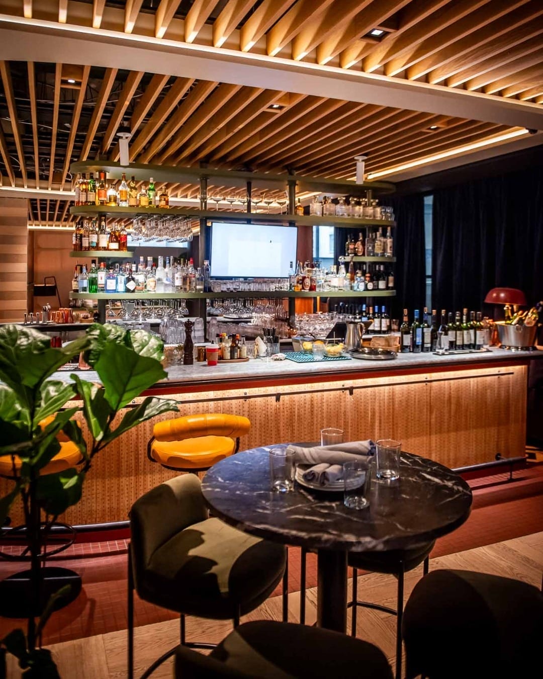 A view of the hotel bar with elegant wood and metal decor, setting the ambiance for Summerlicious 2025 dining in Toronto.