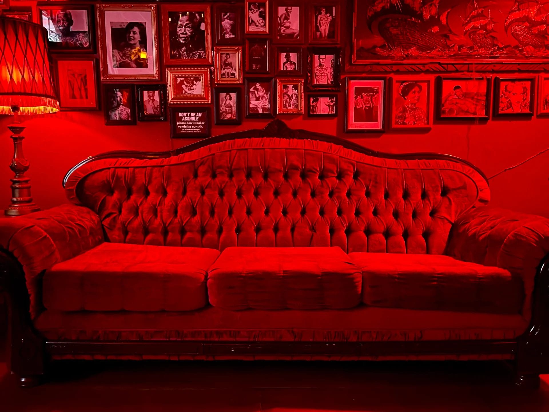 Red velvet seating and vintage décor inside Sweaty Betty’s Bar in Toronto