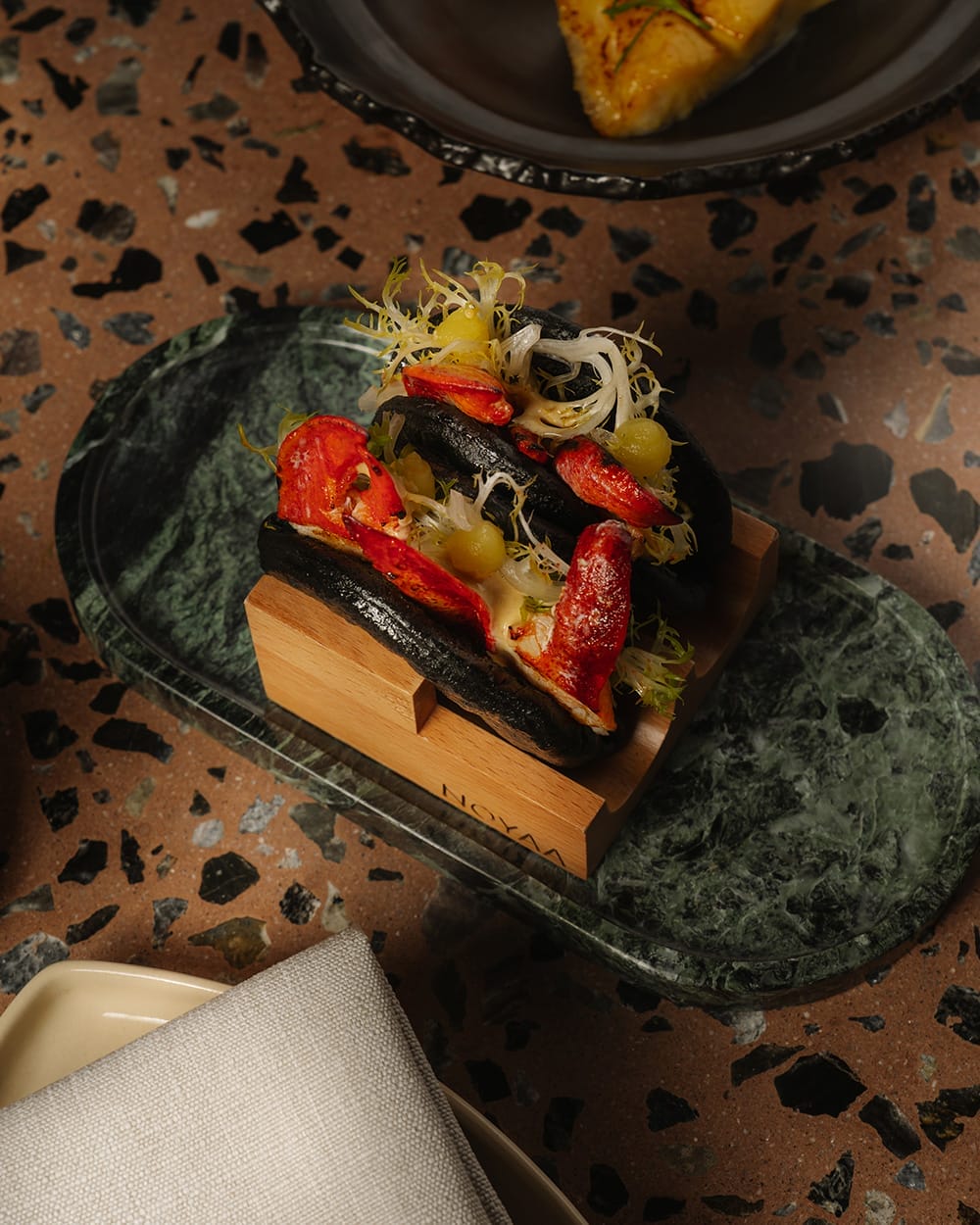 Lobster bao buns and fusion dishes at NOYAA, one of the trendiest new restaurants in Toronto for 2026.