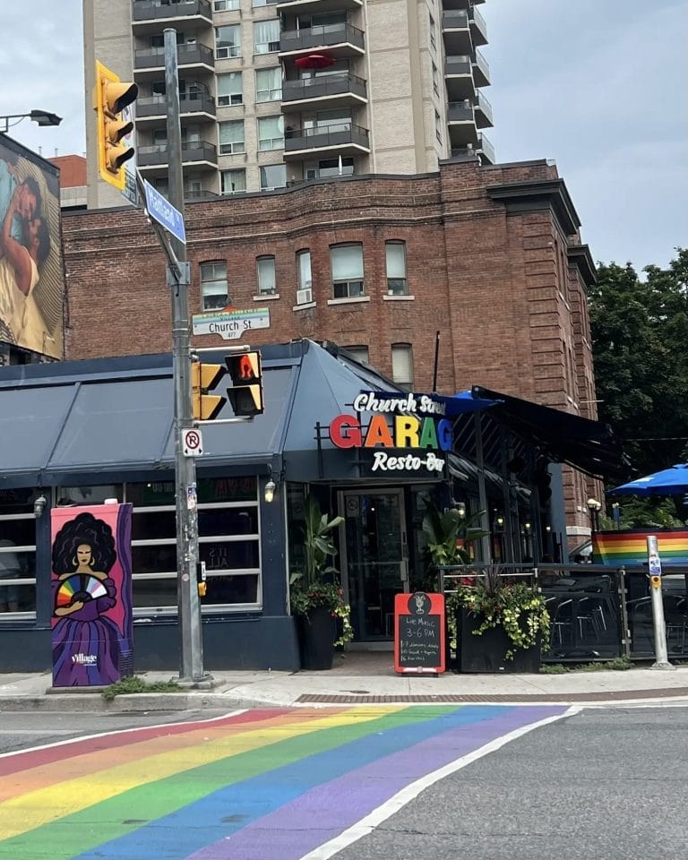 Exterior of Church Street Garage restaurant and bar with rainbow crosswalk in Toronto’s Village neighbourhood.
