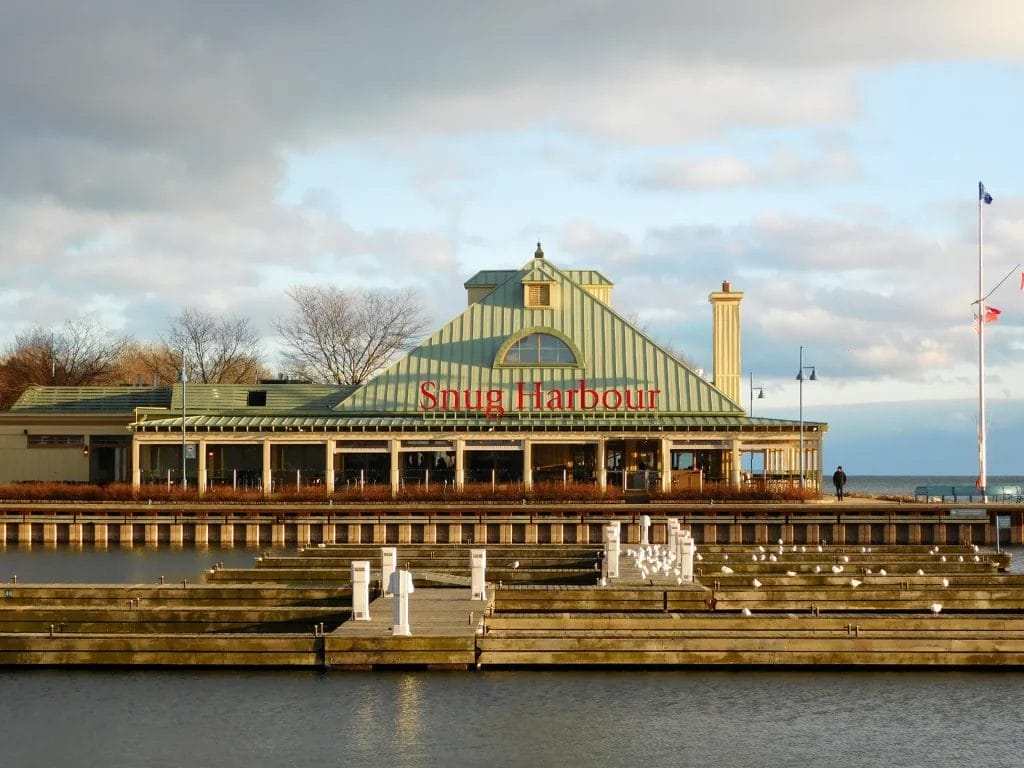 Snug Harbour restaurant on the Mississauga waterfront with marina docks, lake views, and the restaurant sign visible on the building.